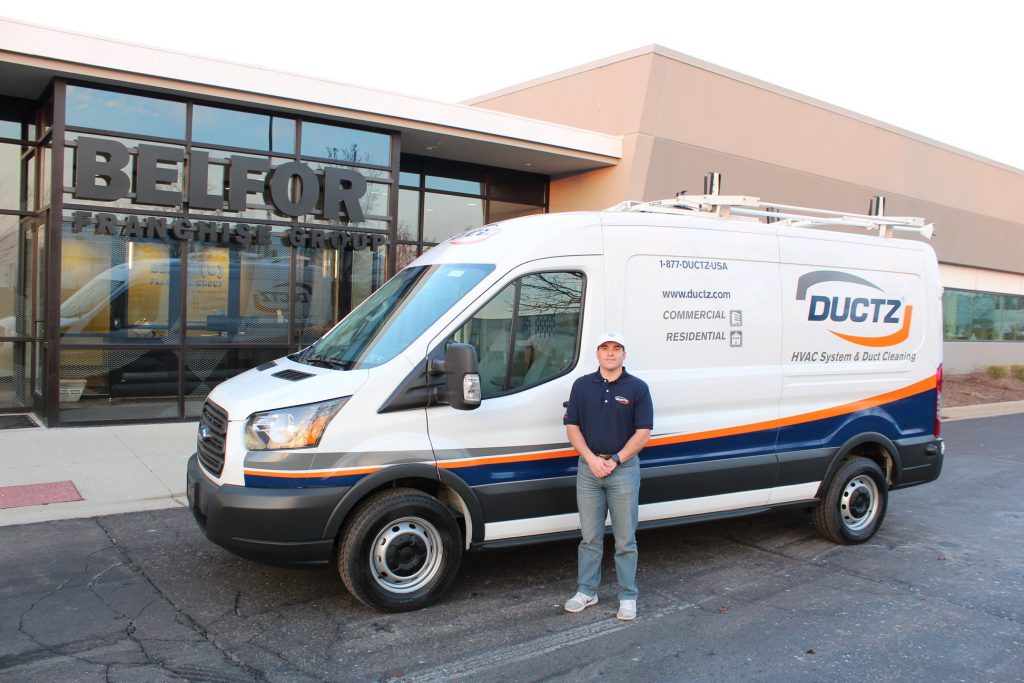 DUCTZ air duct cleaning franchise owner stands with van repeat business